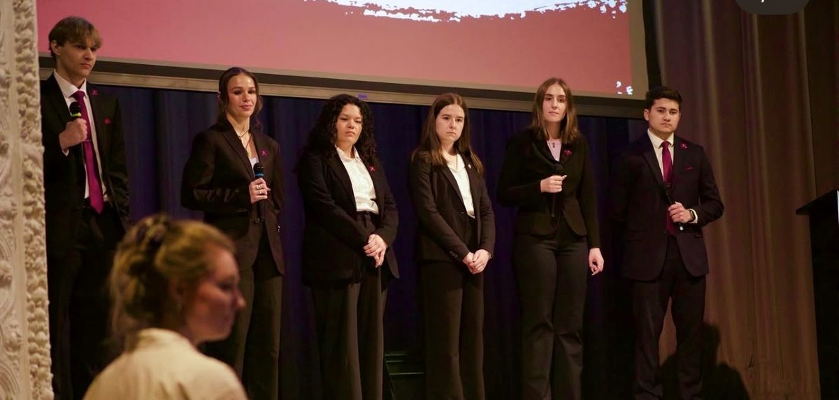 The presentation team standing on stage with microphones during their pitch
